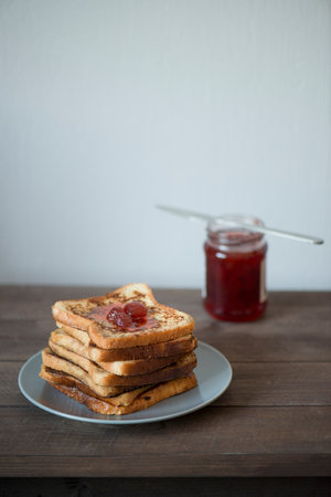 Toasted bread with strawberry jam on wooden table. breakfast concept.の写真素材