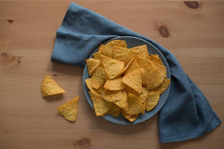Nacho chips in a plate on wooden background. top view