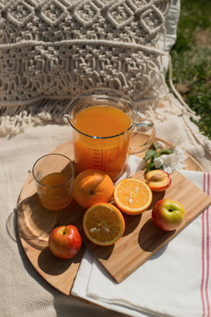 Healthy breakfast in the garden. Fresh juice, apples and orangesの写真素材