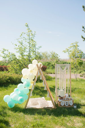 Decorated white tent with balloons on a green grass in summer park.の写真素材