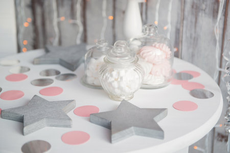 Decorative candies on a white table and wooden form of stars.の写真素材