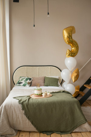 Interior of a bedroom with a double bed with balloons and cake