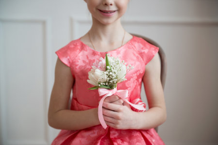 Little girl in a pink dress with a bouquet of white tulipsの写真素材