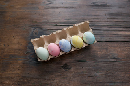 Easter eggs painted in pastel colors on a wooden background.