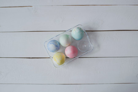 Easter eggs in a cardboard box on a blue and yellow napkin