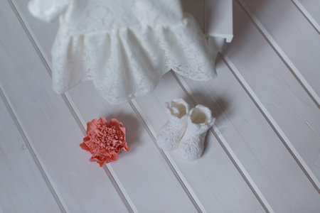 Baby clothes and shoes on a white wooden background. selective focus.の写真素材
