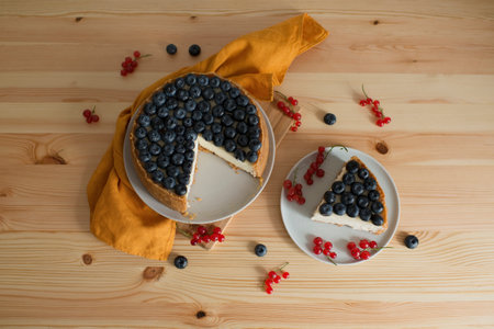 Homemade cheesecake with blueberries and currants on wooden backgroundの写真素材