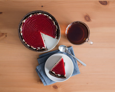 Piece of red velvet cake and cup of tea on wooden tableの写真素材