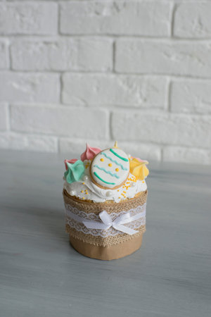 Cupcake with butter cream on a white brick wall background.