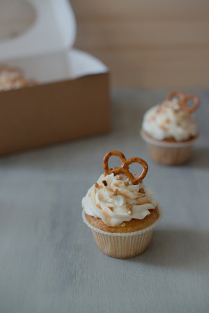 Cupcake with cream and pretzel on wooden background. selective focus.の写真素材
