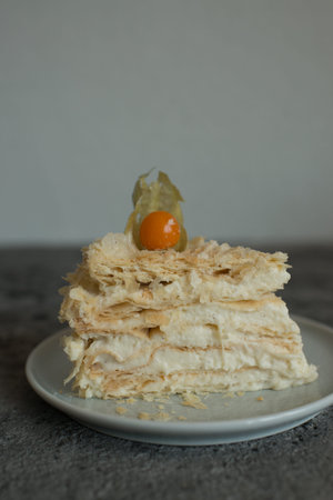Napoleon cake with physalis fruit on white plate on gray backgroundの写真素材