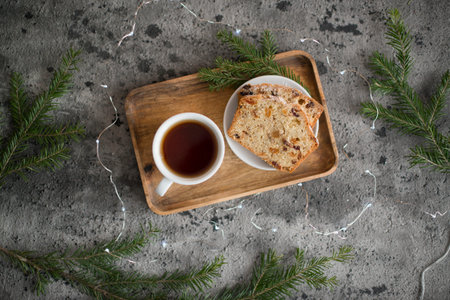 Cup of coffee and cake with raisins on wooden tray