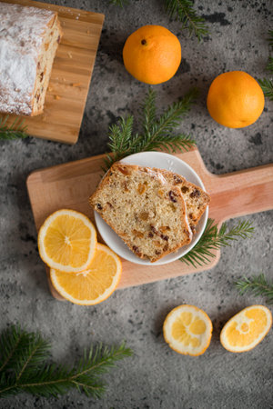 Christmas cake with raisins and oranges on a gray concrete background