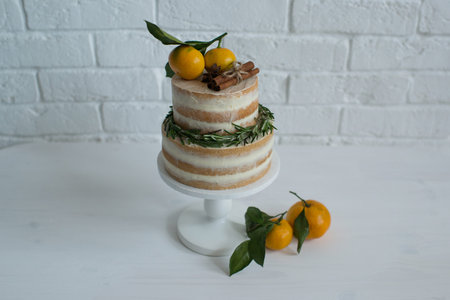 Beautiful cake decorated with tangerines and rosemary.