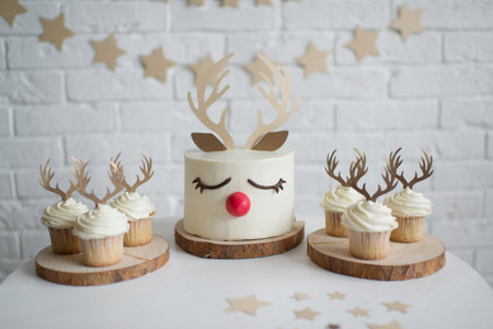 Christmas cupcakes with deer antlers and red nose on a white table