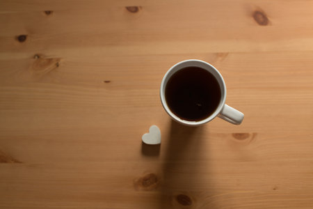 Coffee cup and heart on wooden table. top view.の写真素材
