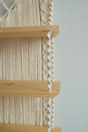 Close up of a wooden shelf with a white knitted rope.