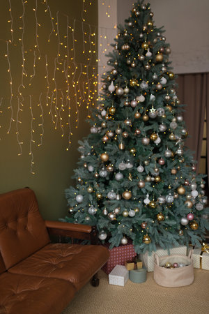 Christmas tree with gifts and a sofa in the interior of the roomの写真素材