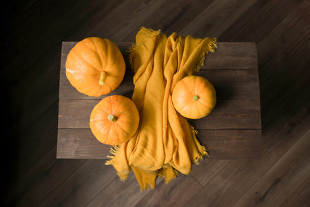 Pumpkin and yellow napkin on wooden table, top viewの写真素材