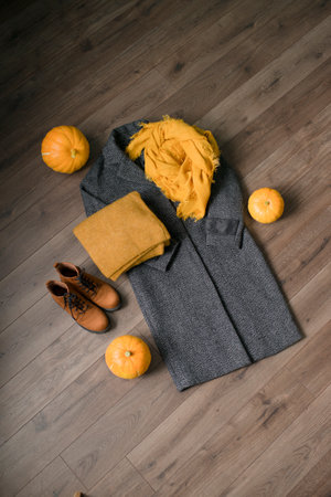 Autumn still life with clothes, pumpkin and boots on wooden backgroundの写真素材