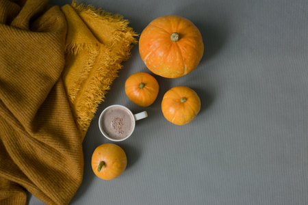 Autumn still life with pumpkins, cup of coffee and orange plaid on gray backgroundの写真素材
