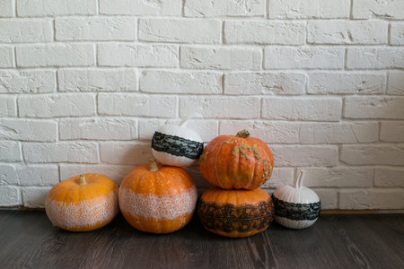 Halloween pumpkins on wooden floor and white brick wall background.の写真素材
