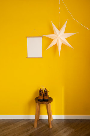 Mockup of a photo frame on a yellow wall with shoesの写真素材
