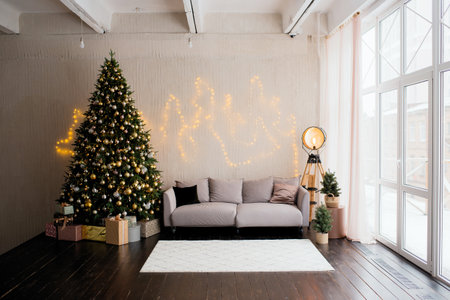 Christmas tree with decorations in the interior of the room with a sofaの写真素材