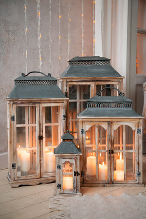 Beautiful vintage lanterns with burning candles in the interior of the roomの写真素材