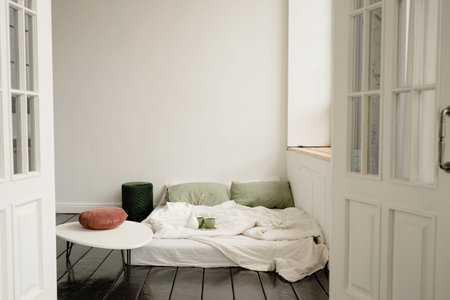 Interior of a bedroom with a white wall and a wooden floorの写真素材