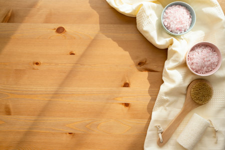 Spa setting with bath salt and towel on a wooden background.の写真素材