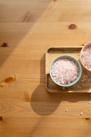 Bath salt in bowl on wooden background, top view.の写真素材