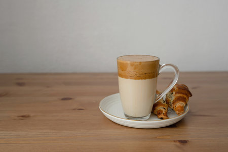 Cappuccino coffee with croissants on wooden table.の写真素材