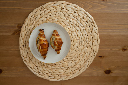 Croissants on a plate on a wooden background. top viewの写真素材