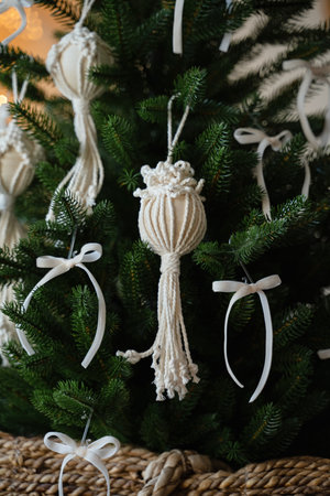 White knitted toy on the branches of a christmas tree.の写真素材