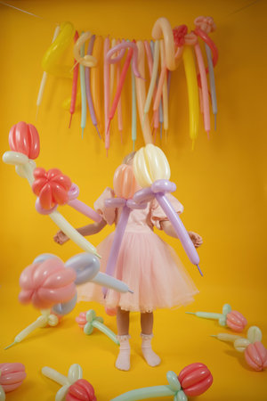 Children's birthday party. A girl in a pink dress with balloons.の写真素材