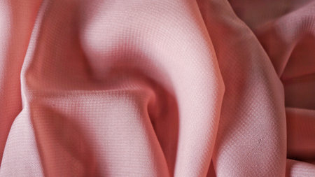 Pink silk background. The texture of the pink polycotton fabric is smooth and soft with beautiful close-up fabric details. Textile pattern with dense, breathable and flexible fiberの写真素材