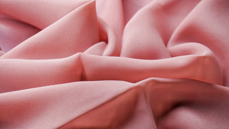 Pink silk background. The texture of the pink polycotton fabric is smooth and soft with beautiful close-up fabric details. Textile pattern with dense, breathable and flexible fiberの写真素材