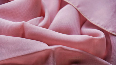 Pink silk background. The texture of the pink polycotton fabric is smooth and soft with beautiful close-up fabric details. Textile pattern with dense, breathable and flexible fiberの写真素材
