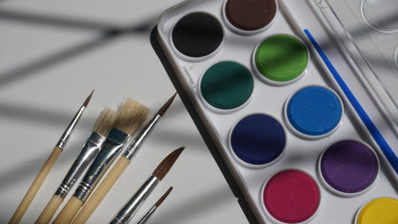 Watercolor paints, brushes and watercolors on a white background