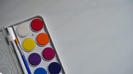 Watercolor paints and brushes on a white background, close-upの写真素材