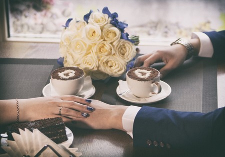 Filming by a close up of the hands holding warm coffee. Newlyweds have coffee.の写真素材