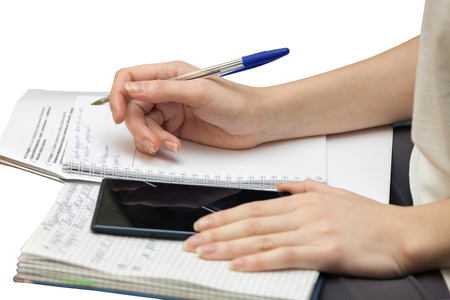 hands of a white young woman doing pen notes in a diary  isolated on a white backgroundの写真素材