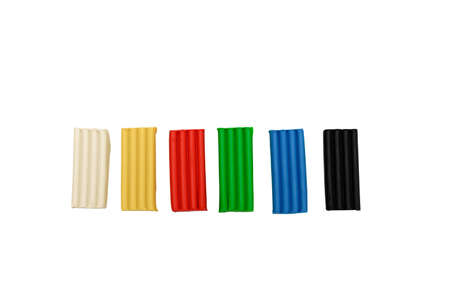 plasticine lies in a row white, yellow, red, green, blue, black, platiline top view isolate white backgroundの写真素材