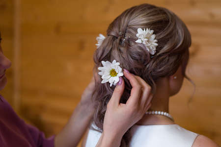 bridal hairstyle with natural white chamomile flowers in hair close-upの写真素材