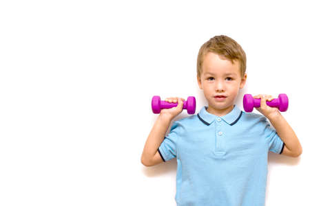 child with dumbbells. little boy lifts up with dumbbells isolate on a white background. Children's sports, training and health concept. space for textの写真素材