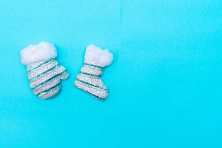 Christmas and New Year concept layout. White fluffy mittens with sequins on a blue background, place for text.の写真素材