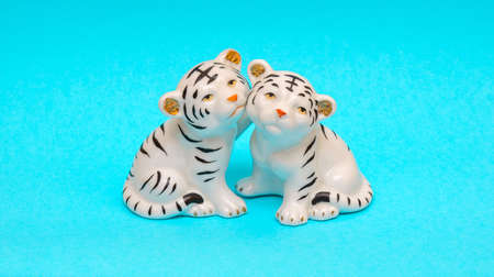 Porcelain figurines of white tigers on a blue backgroundの写真素材