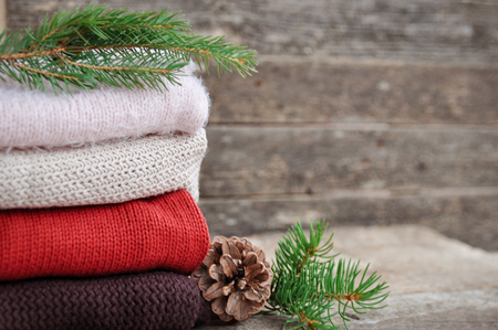 Cozy winter: knitted clothes, spruce, cones on an old wooden background. Holidaysの写真素材