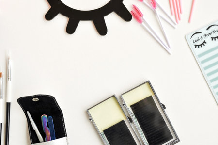 Beauty of eyelashes and eyebrows: eyelash extension tools and decor on white background with copy...